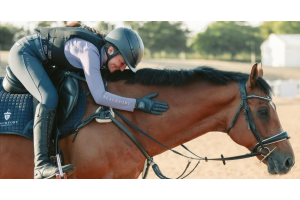 Rider leaning forward to hug a bay horse during a relaxed schooling session, highlighting harmony, trust and a positive horse-and-rider connection. Image credit: @harrys_newchapter.